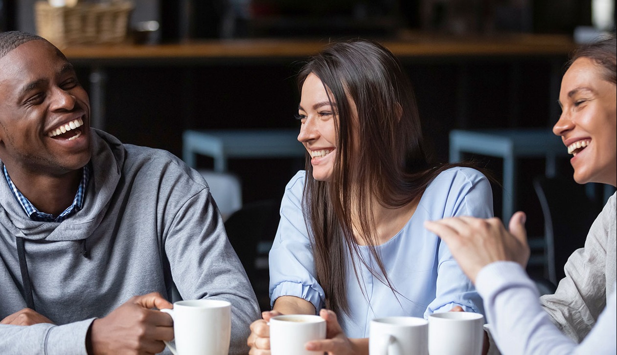 2 men and a woman drinking coffee and smiling