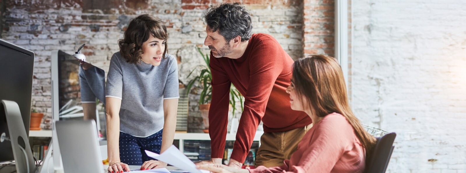 young group of coworkers huddled at a desk